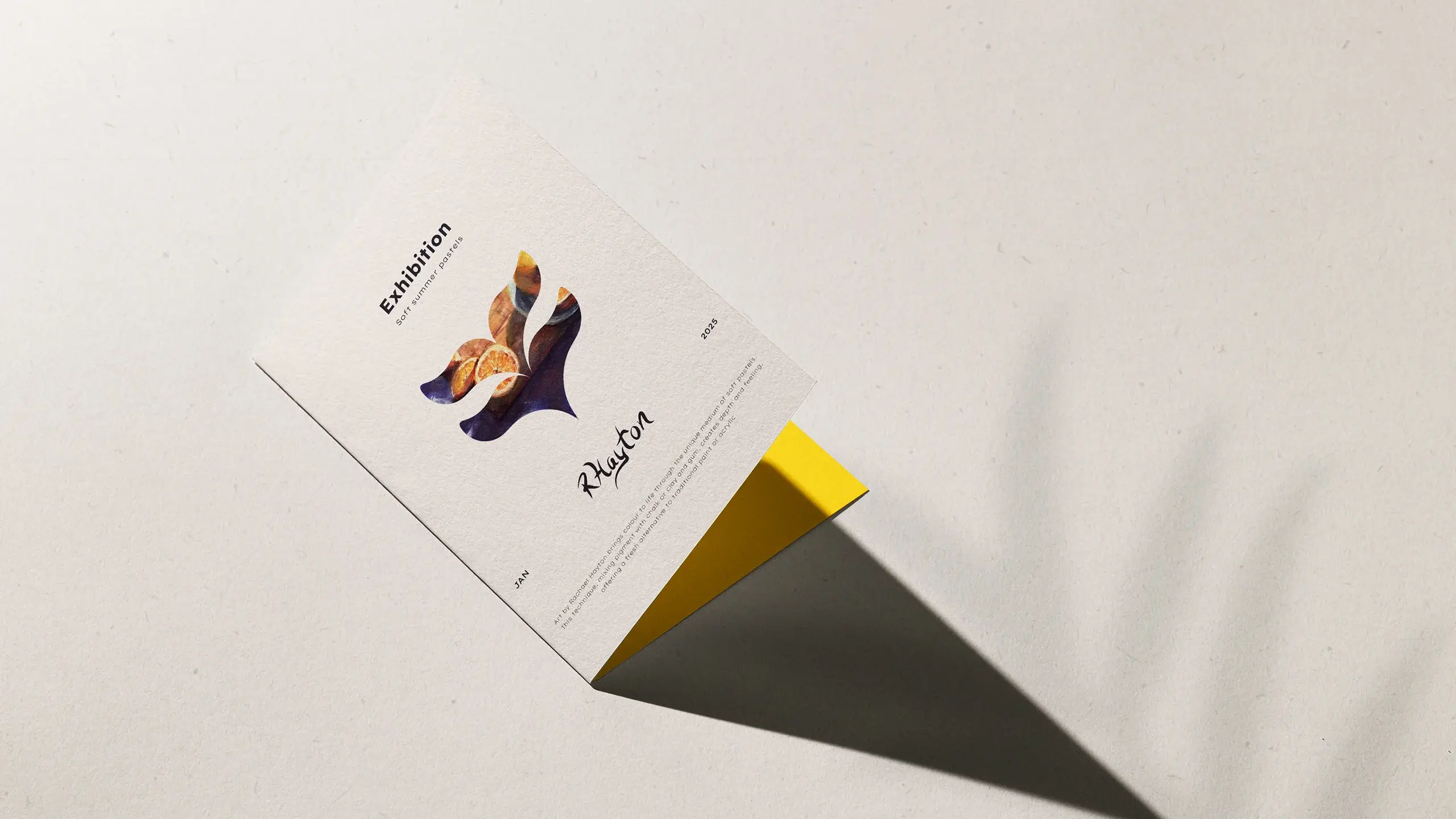 An A5 folded paper flyer with graphics on the front, and yellow internal page placed on a cream coloured recycled paper background