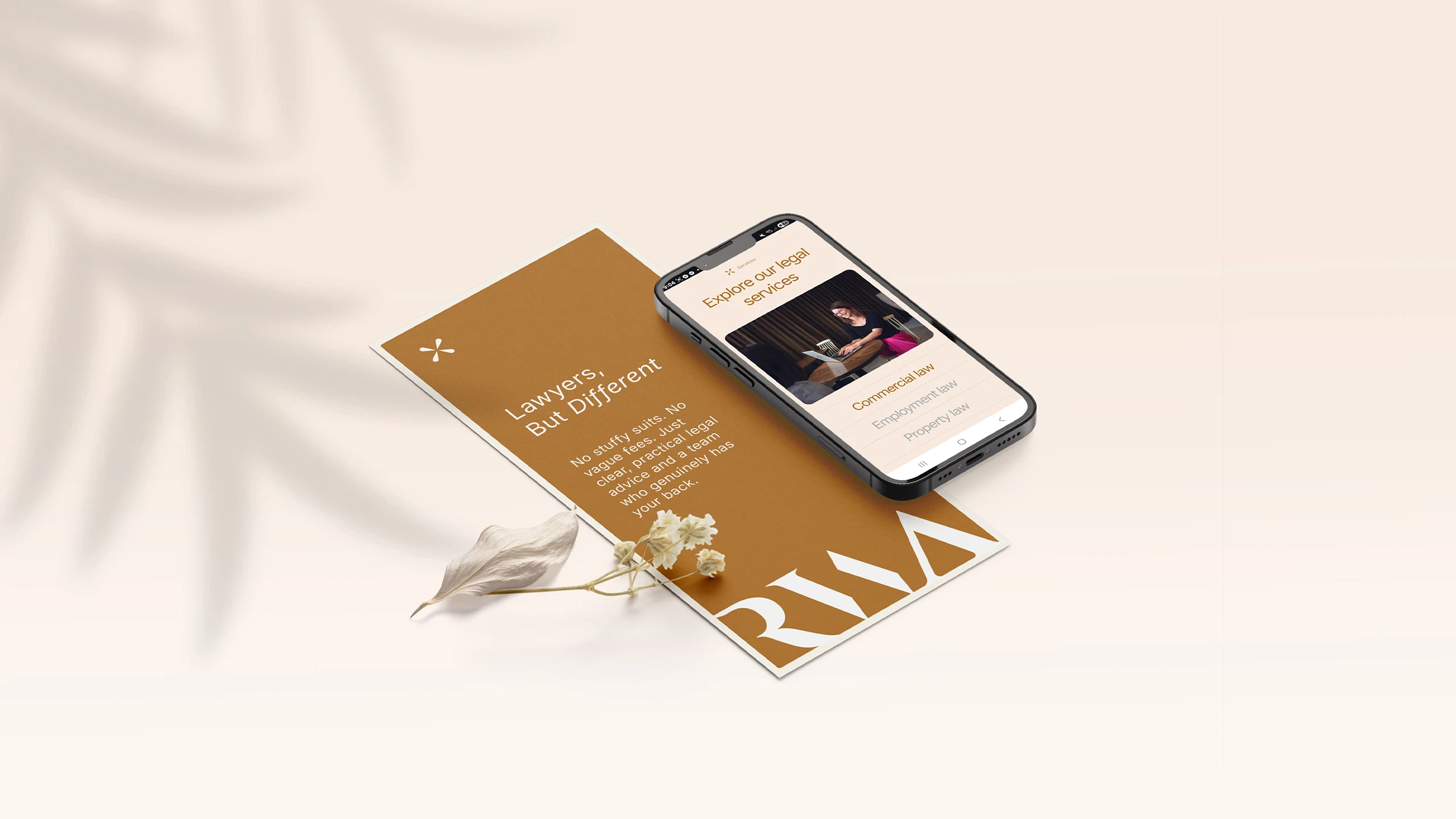 RWA lawyers branded DLE flyer and mobile device mocked up with a small dried flower on a cream background and leaf-shaped shadows on the left